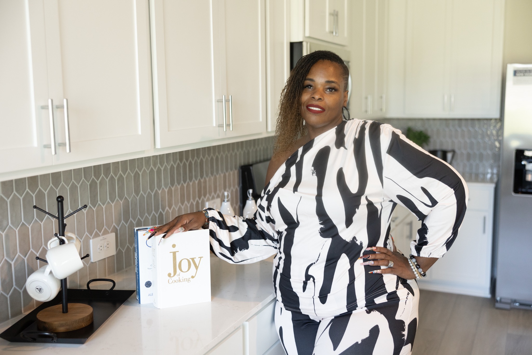 Kay Matthews in a kitchen with a Joy of Cooking cookbook.
